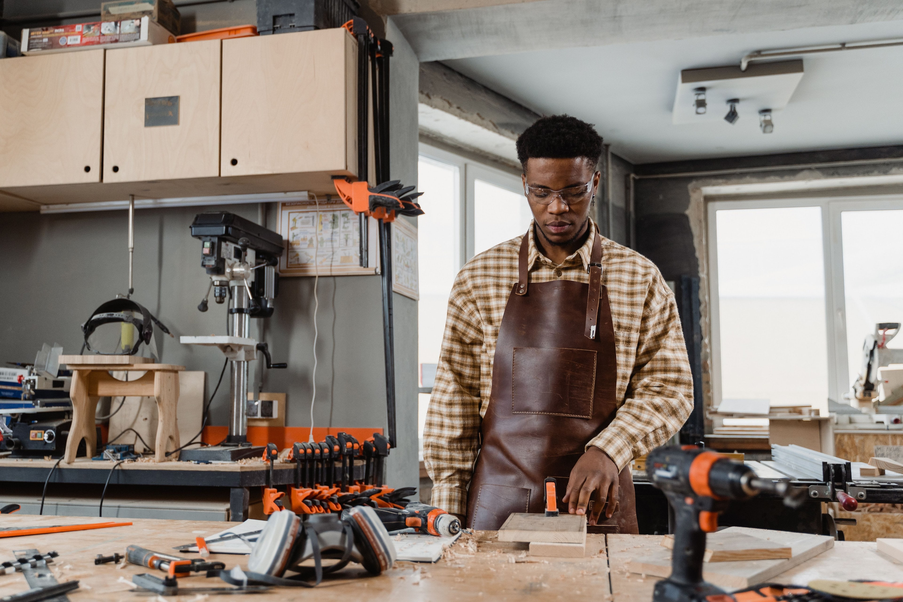 Artisan en tablier de cuir au travail dans son atelier.